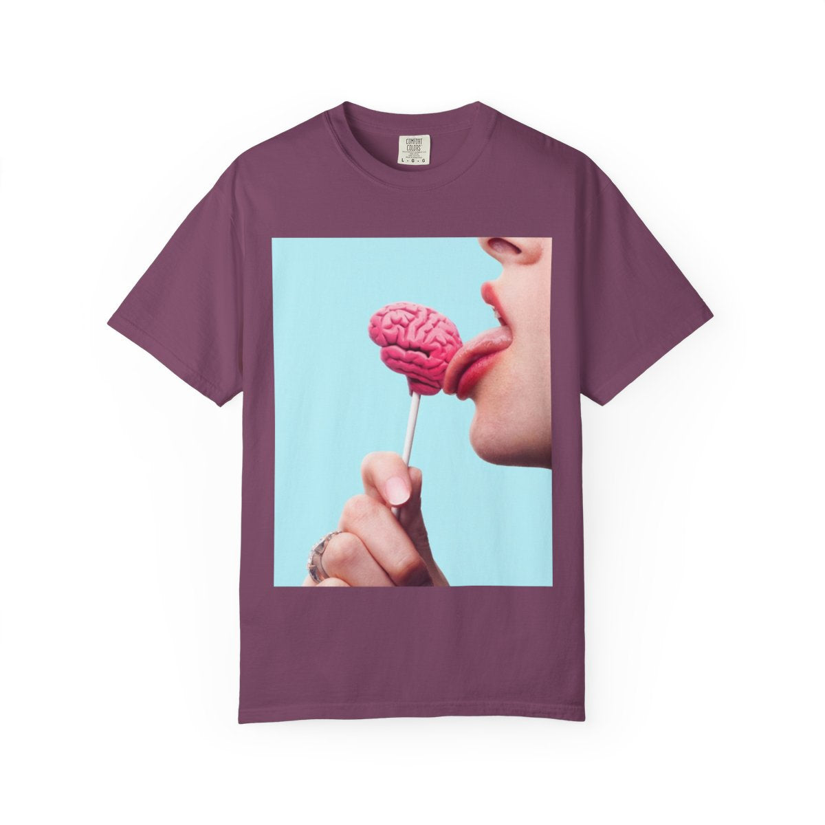 Lickin Brain T-Shirt in Berry with a surreal print of a tongue licking a pink brain lollipop against a turquoise background.