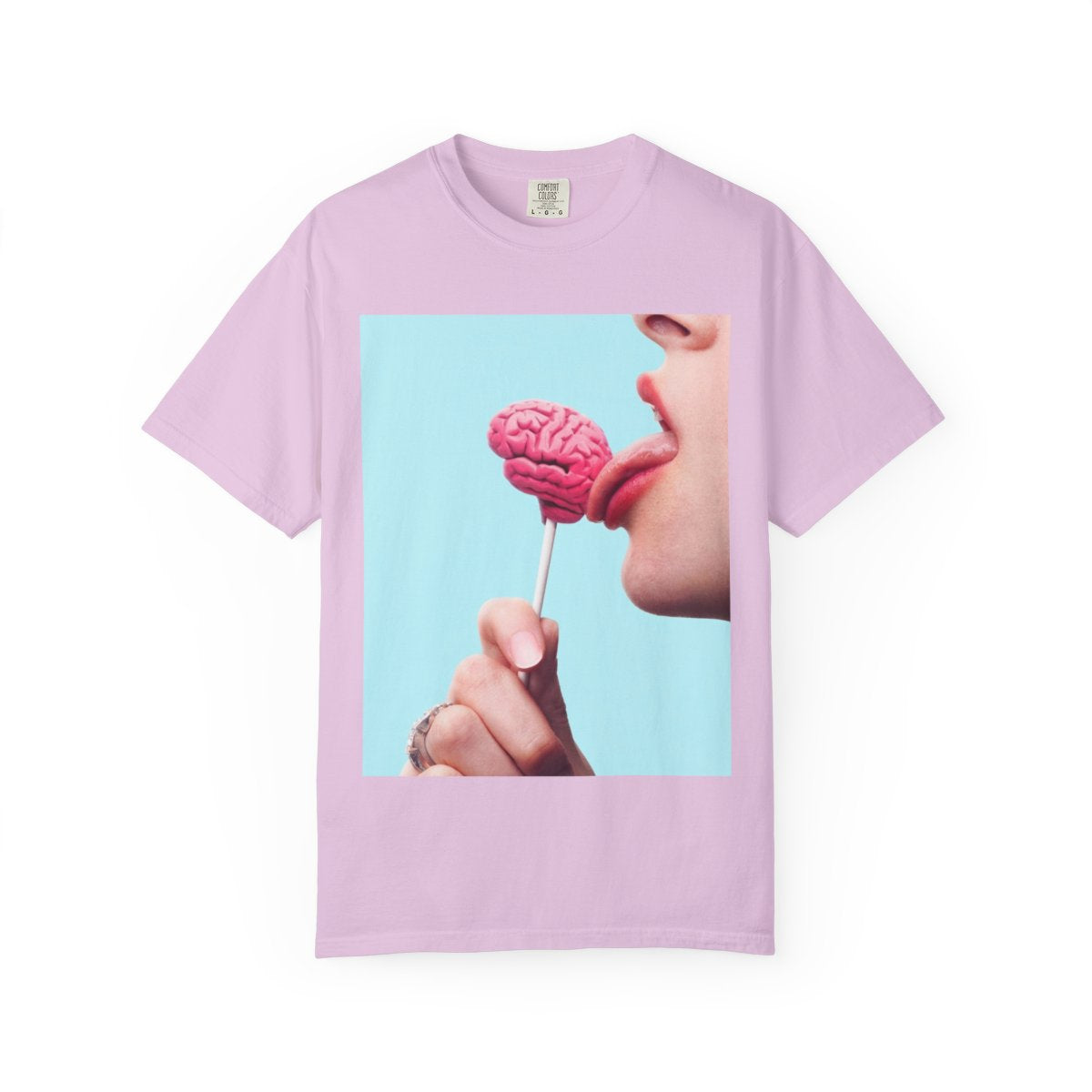 Lickin Brain T-Shirt in Orchid with a surreal print of a tongue licking a pink brain lollipop against a turquoise background.